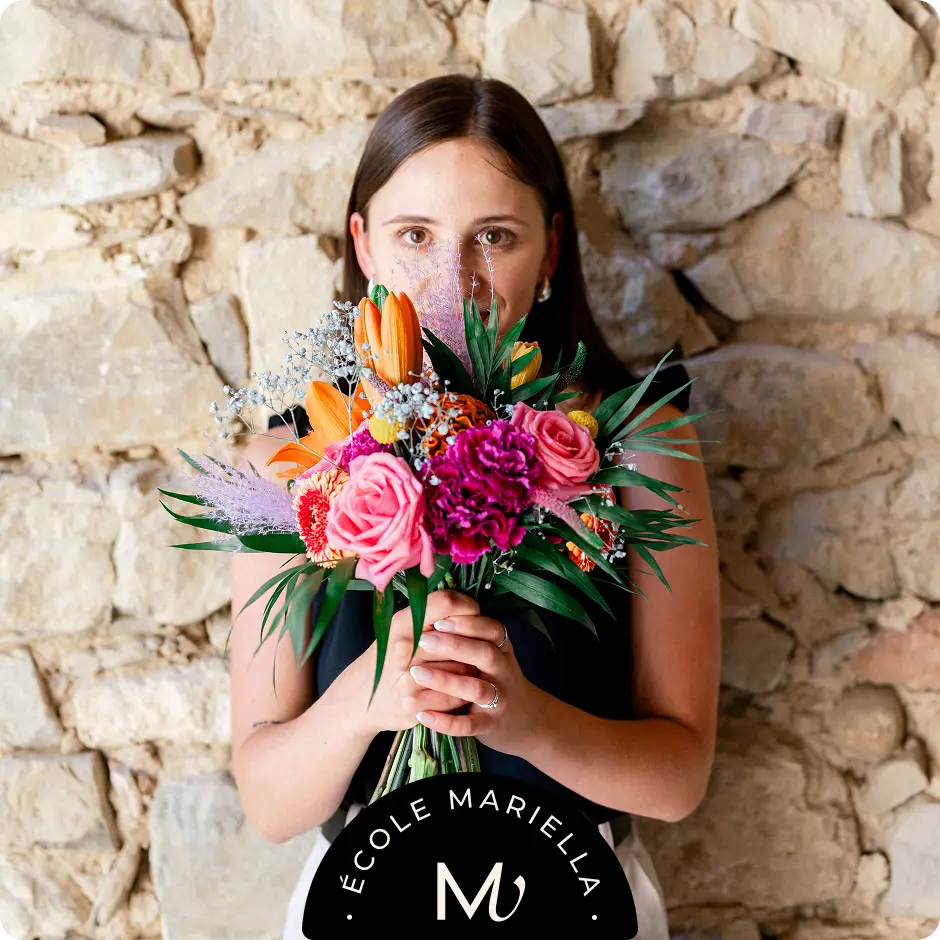 Formation Wedding Floral : Femme tenant un bouquet de fleurs, dans le cadre d'une organisation de mariage pour une décoration florale élégante.
