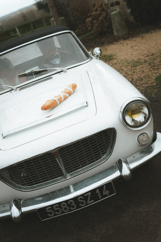 baguette de pain posée sur une voiture de mariés 