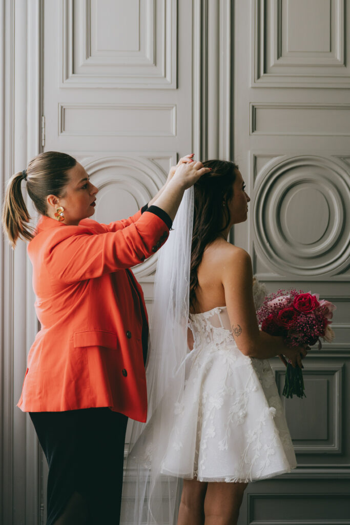 wedding designer qui aide la mariée avec son voile