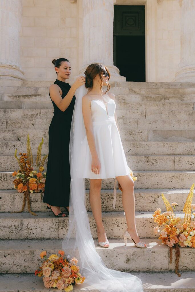 wedding planner qui pose le voile de la mariée.