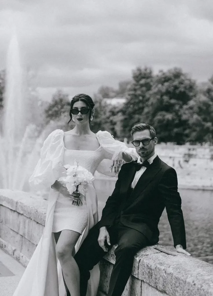 Couple de mariés devant des colonnes anciennes aux Jardins de la Fontaine à Nîmes.