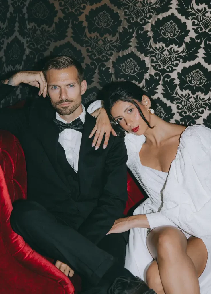 Mariés élégants avec lunettes noires et verres ornés de rubans rouges pendant un shooting mariage