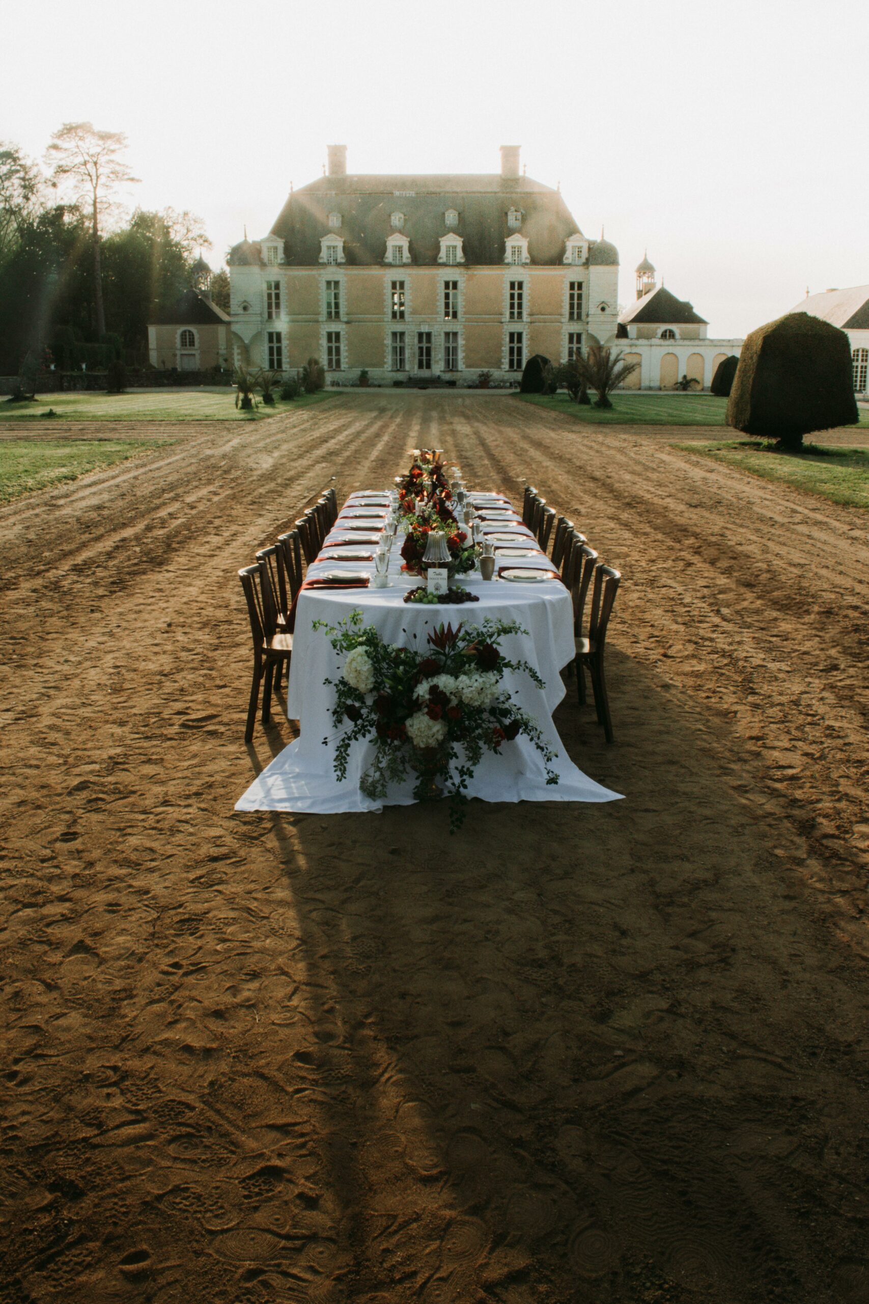 Façade en tuffeau du Château du Boschet en Bretagne, décor de mariage dolce vita avec salon en rotin et vases Médicis